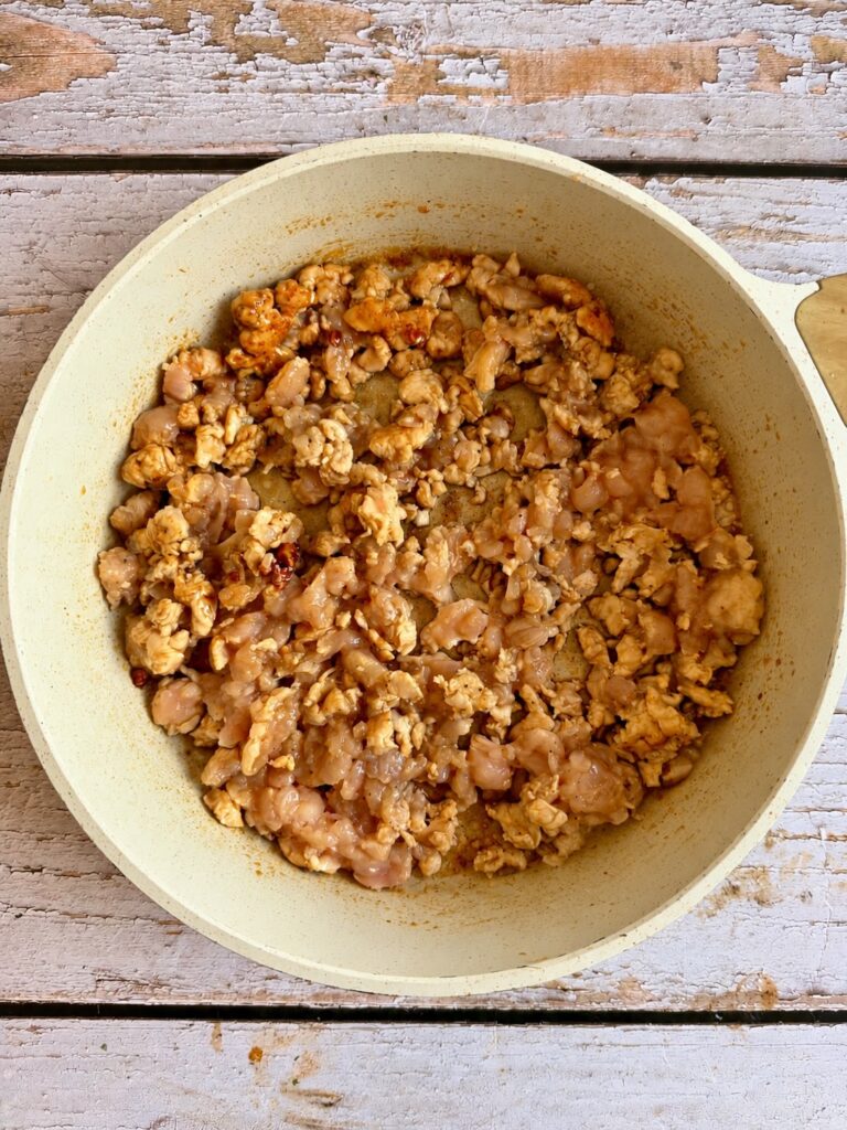 Ground chicken cooking in a frying pan.