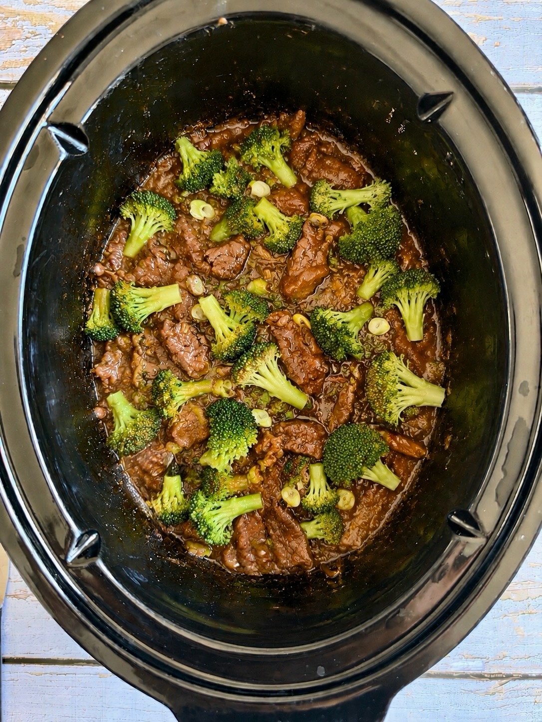 Mongolian beef and broccoli in a thick savory sauce in a slow cooker.